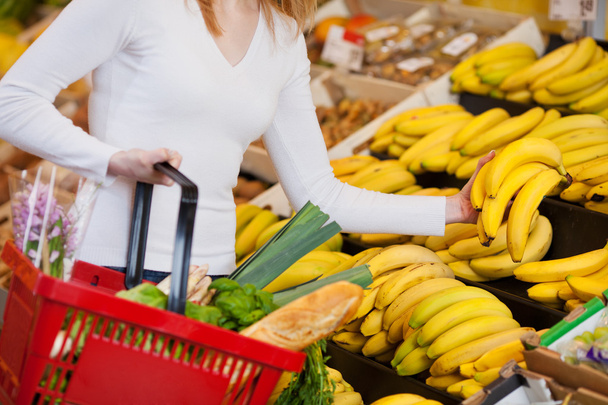 Woman Choosing Bananas In Grocery Store - Фото, зображення