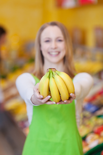 Female Worker Holding Bananas In Grocery Store - Fotografie, Obrázek