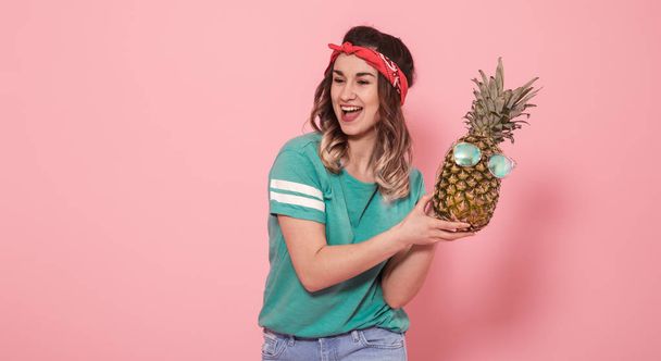 Portrait d'une fille avec un ananas sur fond rose
 - Photo, image