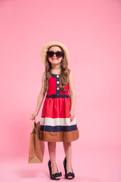 little fashionista on a colored background in mom's shoes - 写真・画像