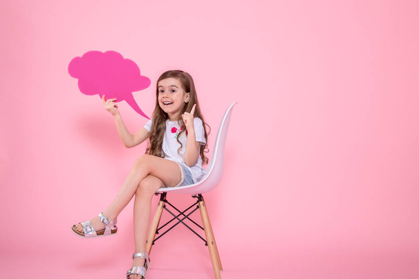 niedliches kleines Mädchen mit einer Ikone einer Rede auf rosa Hintergrund - Foto, Bild