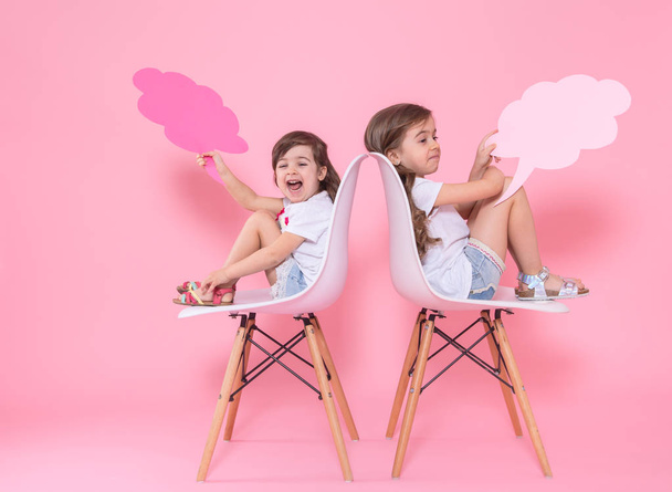 dos chicas en un fondo de color con iconos del habla
 - Foto, Imagen