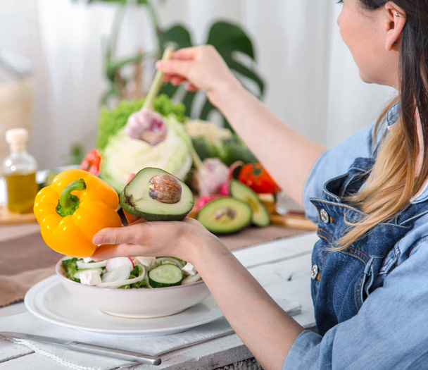 junge und glückliche Frau isst Salat am Tisch - Foto, Bild