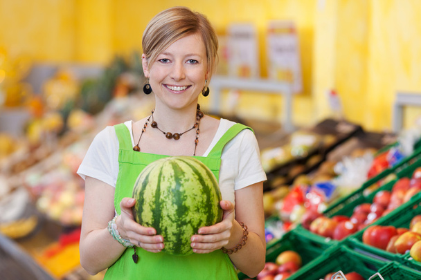 Saleswoman showing a fresh watermelon - Foto, Imagem