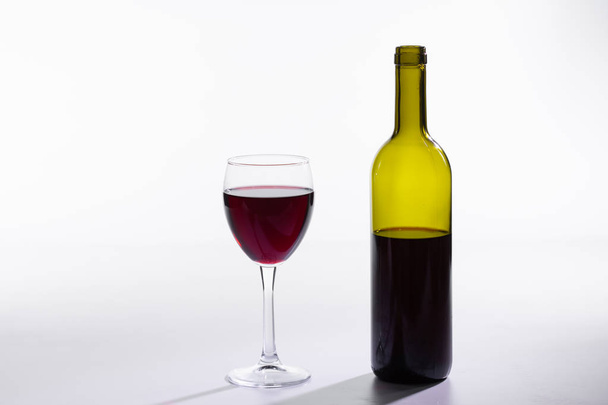 Verre et bouteille de vin rouge sur fond blanc
 - Photo, image