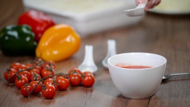 Žena v kuchyni dělá rajčatovou omáčku. Přidat koření do rajčatového pyré - Záběry, video