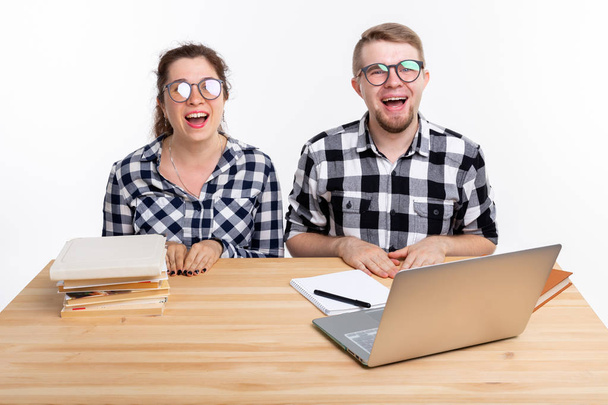 Emberek és oktatási koncepció - két diák öltözött kockás ing ül az asztalnál - Fotó, kép