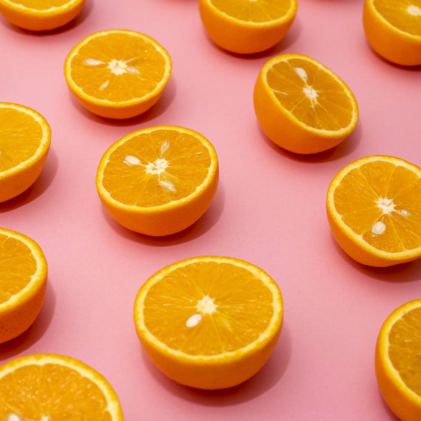 Orange juicy oranges split in half on pink - Foto, Imagen
