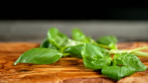 Super slow motion of falling basil on cutting board - Imágenes, Vídeo