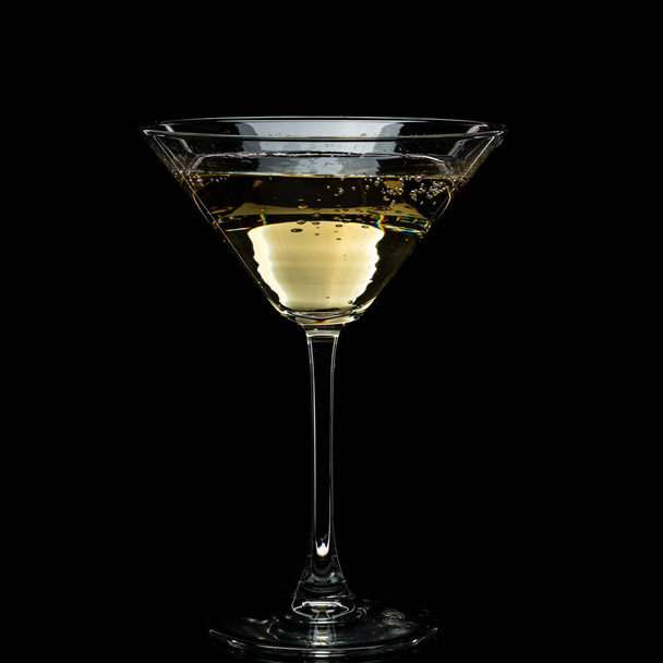 in a martini glass, vermouth ice falls, and splashes with drops on a black background - Photo, image