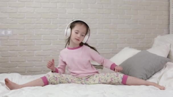 little child baby girl listening to the music with headphones - Video, Çekim