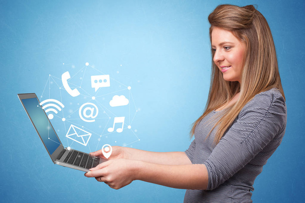 Woman holding laptop with online symbols - Φωτογραφία, εικόνα