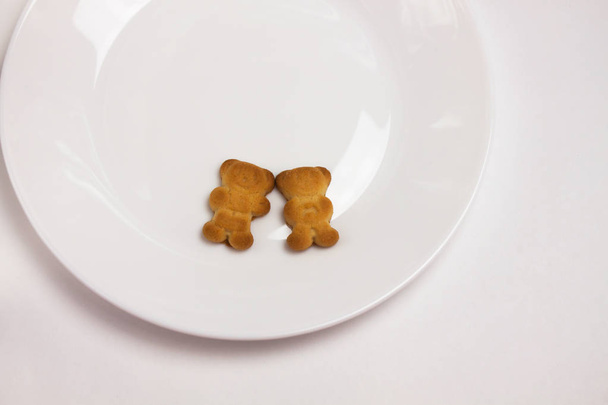 Милі ведмеді печиво на керамічній круглій тарілці ізольовані на білому тлі. Вид зверху, плоский ліжко
. - Фото, зображення