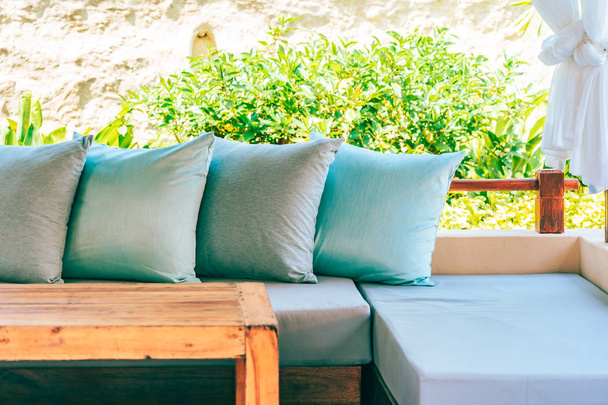 Travesseiro no sofá cadeira decoração pátio ao ar livre com vista para o jardim para relaxar e lazer
 - Foto, Imagem