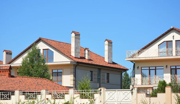 Bella casa moderna di lusso suburbana con tetto in argilla rossa, balcone, recinzione, camino, garage, patio
 - Foto, immagini