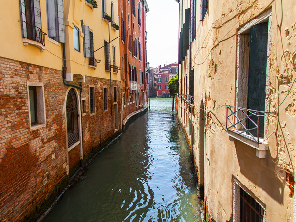 Venice, Italy, on April 25, 2019. The picturesque narrow channel typical for Venice, and old buildings on its coast - Foto, Imagen