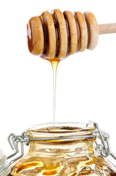 Jar of honey with wooden drizzler - Foto, immagini