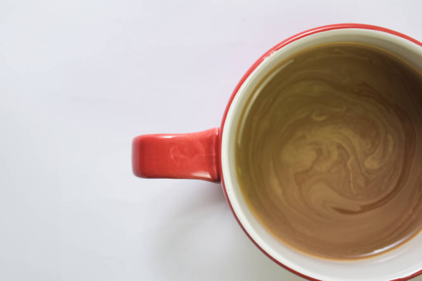 Közelről forró cappuccino kávét egy piros pohár izolált fehér alapon. Szelektíven összpontosítani piros csésze - Fotó, kép