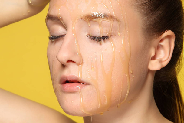 Woman with honey on her face. - 写真・画像