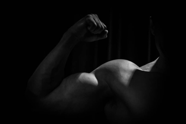 athlete shows pumped hand close-up on a black background. bodybuilding mr. olympia - Foto, imagen