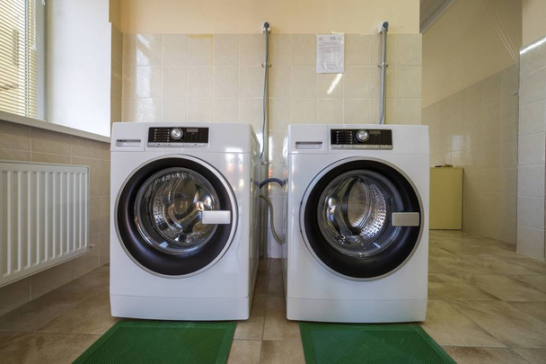 Moderne nieuwe industriële wasmachines in schone betegelde badkamer o - Foto, afbeelding