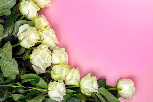 beautiful white roses on a pink background. place for text. top view background - Foto, afbeelding