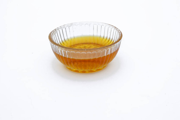 Raw organic honey or nectar in a transparent glass bowl isolated on white. - Zdjęcie, obraz