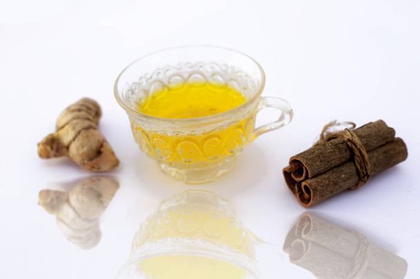 Popular turmeric tea isolated on white with its entire ingredients which are turmeric powder and raw, honey and cinnamon sticks.Used for detoxifying body.Isolated on white. - Φωτογραφία, εικόνα