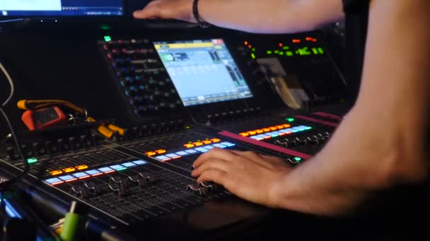 Male dj adjusting controls at mixing console in nightclub. DJ mixer player. DJ at sound console. shot of professional musician hands, people create music on mixer with the help of sliders. hd - Séquence, vidéo