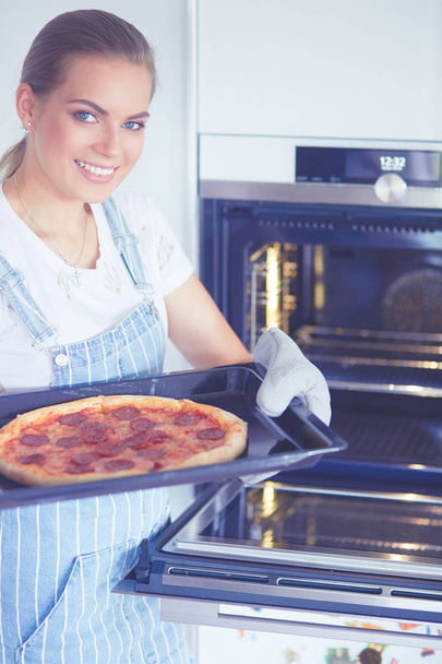Mutlu genç bayan evde pizza pişiriyor. - Fotoğraf, Görsel