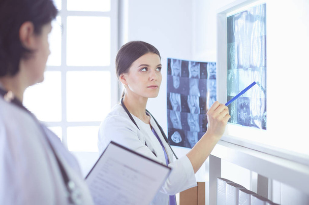 Two female doctors pointing at x-rays in a hospital - Photo, image