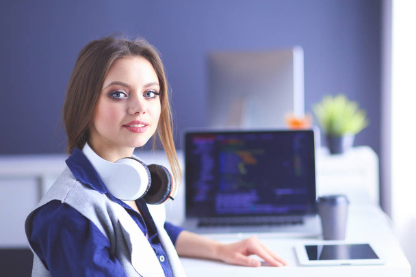 Young confident businesswoman working at office desk and typing with a laptop - Foto, Imagen