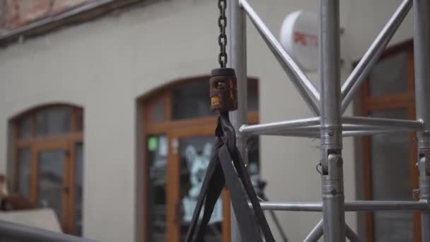 View of small crane hook with chain connected to grey aluminium structure. - Footage, Video