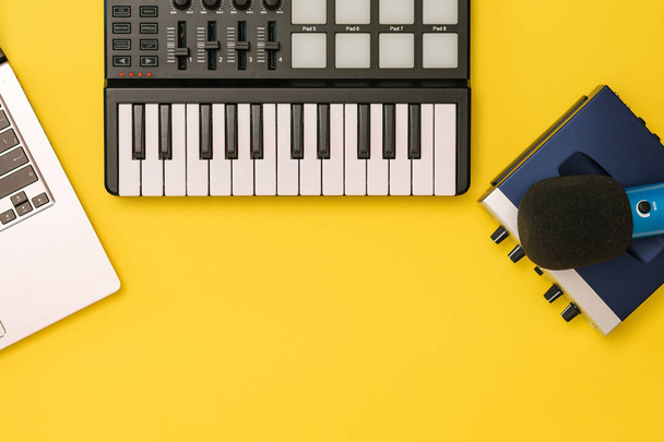 Muziek mixer, geluidskaart, laptop en microfoon op gele achtergrond. Het concept van de organisatie van de werkplek. - Foto, afbeelding