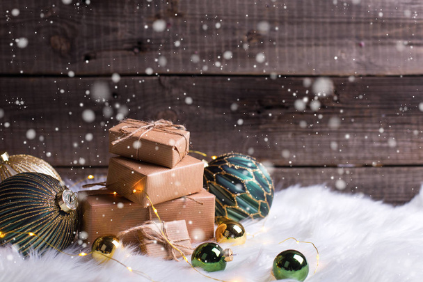 Stapel von verpackten Geschenken, goldenen und grünen Kugeln und Elfenlichtern - Foto, Bild