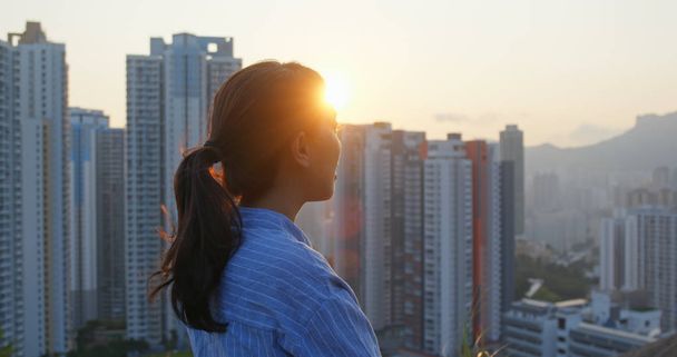 Femme profiter de la vue sur le coucher du soleil dans la ville de Hong Kong
 - Photo, image