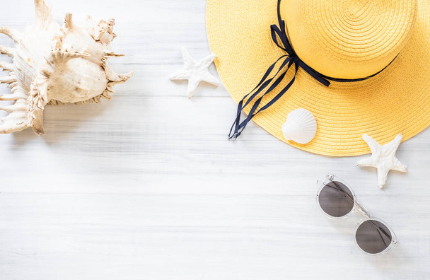 Draufsicht auf den sommergelben Frauenhut mit Sonnenbrille und Muschel - Foto, Bild