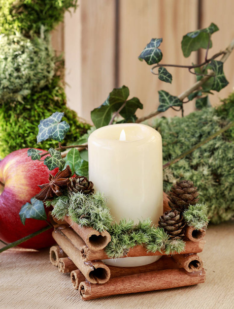 Christmas candle holder with cinnamon sticks, moss and anise sta - Photo, image