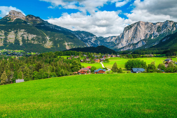 Прекрасный летний пейзаж альпийской деревни с зелеными полями и горами
 - Фото, изображение