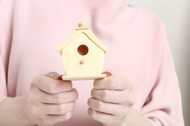 Woman holding tiny wooden house. - Фото, зображення