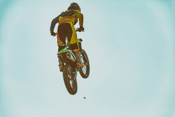 Una foto de un motociclista haciendo un truco y salta en el aire
 - Foto, imagen