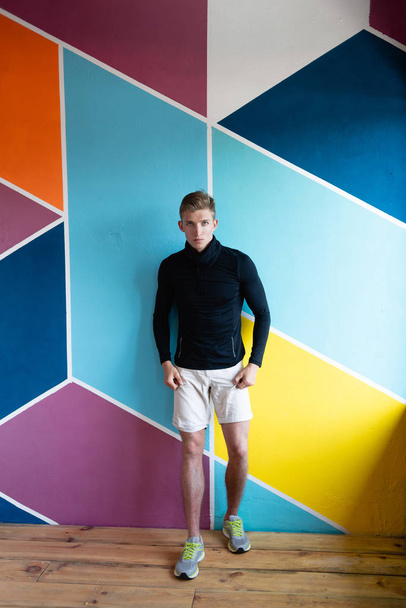 the guy on the background of the colored wall strides forward. - Zdjęcie, obraz