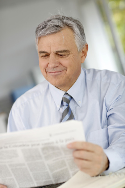 Portrait of senior businessman reading newspaper - Photo, Image