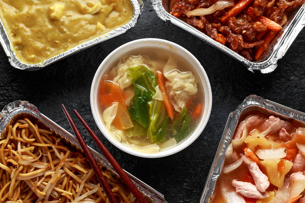 Κινέζικο φαγητό σε πακέτο. Σούπα με ζυμαρικά από χοιρινό, τραγανιστό βοδινό, γλυκό και ξινό κοτόπουλο ανανά, Νουντλς αυγών με φύτρα φασολιών, Κάρι. - Φωτογραφία, εικόνα