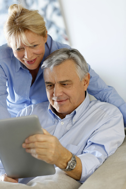 Modern senior couple websurfing on tablet - Zdjęcie, obraz