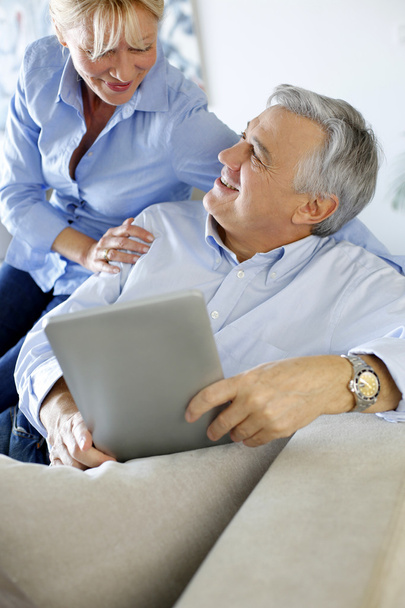 Modern senior couple websurfing on tablet - Foto, Imagen