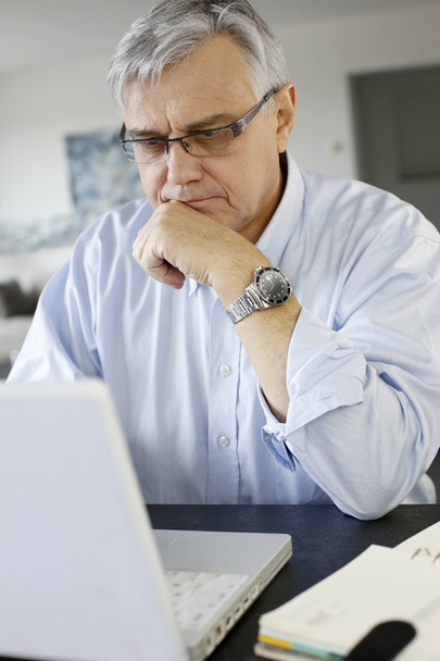 Senior businessman working from home on laptop - Zdjęcie, obraz