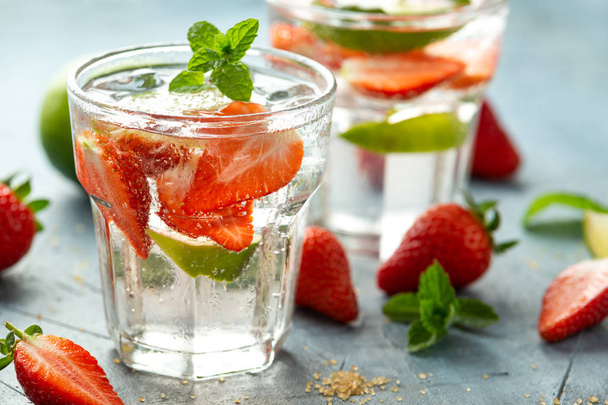 Strawberry Mojito cocktail with Rum, lime and mint in glass. Summer cold drink with ice - Photo, Image
