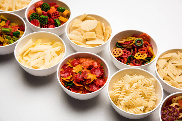 Οι πελλέτες σνακ είναι μη ανεπτυγμένα προϊόντα φτιαγμένα με πρώτες ύλες όπως δημητριακά, πατάτες ή σκόνες λαχανικών, αργότερα επεξεργασμένα με τη χρήση τηγανίσματος, ψησίματος θερμού αέρα. πολυχρωματισμένα/διαμορφωμένα σνακ έτοιμα για φαγητό - Φωτογραφία, εικόνα