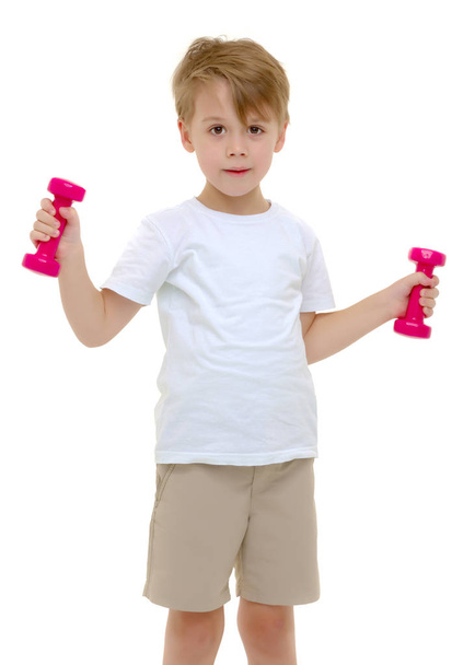 A little boy is lifting dumbbells. - Fotó, kép